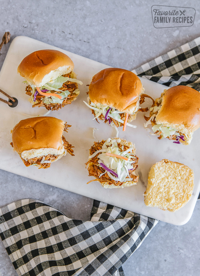Pulled pork sliders on a marble tray with a black and white checkered napkin underneath