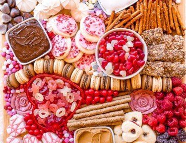 dessert charcuterie board with colorful valentine treats and dips
