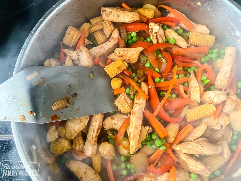 Chicken and vegetables in a skillet.