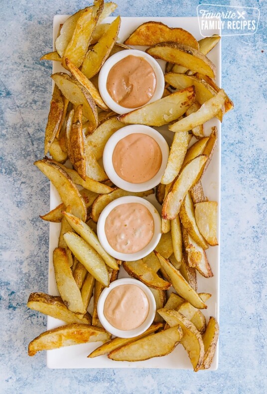 Four kinds of fry sauce on a bed of French fries