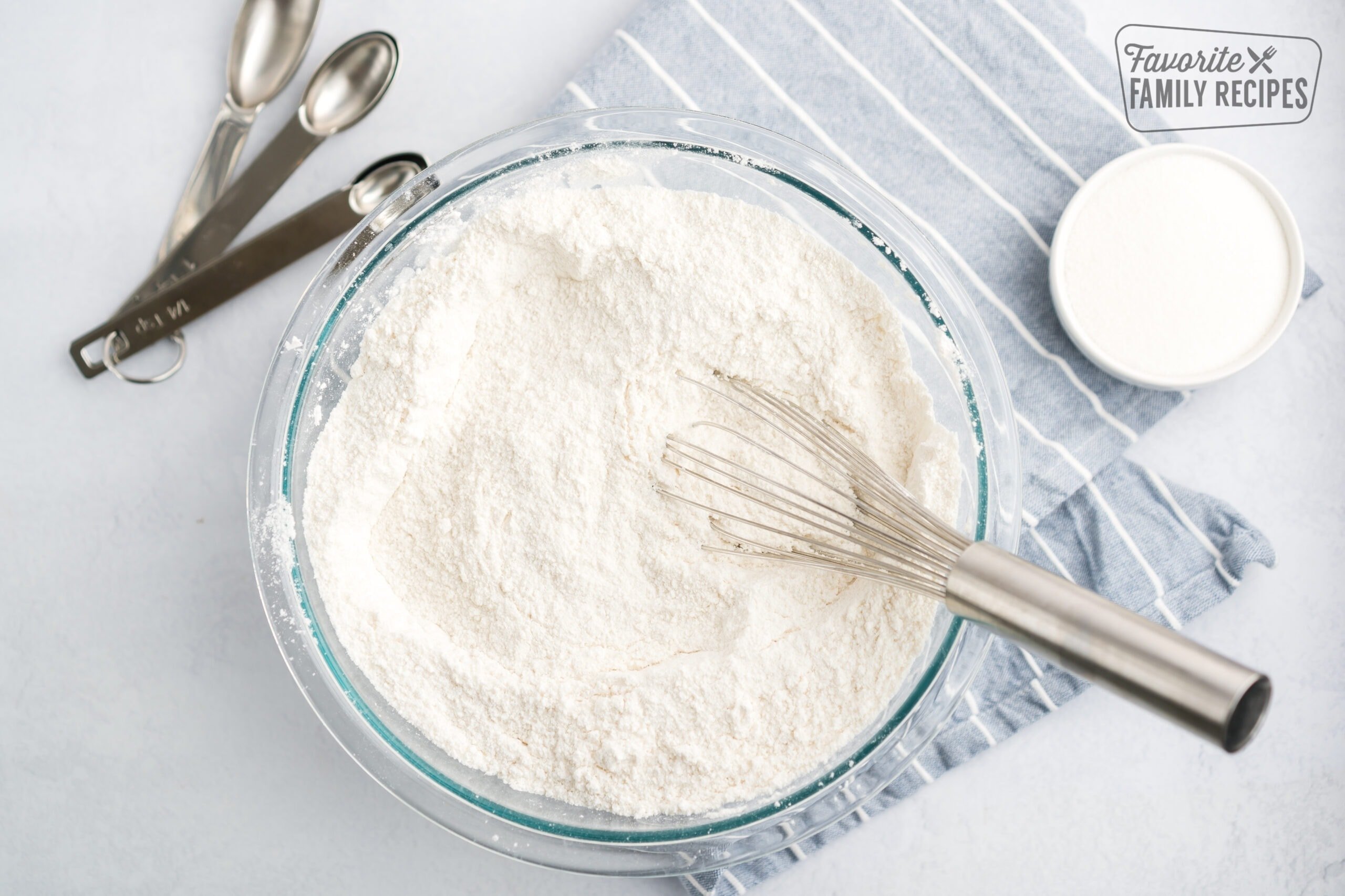 A mixing bowl of Homemade cake mix with a whisk inside.