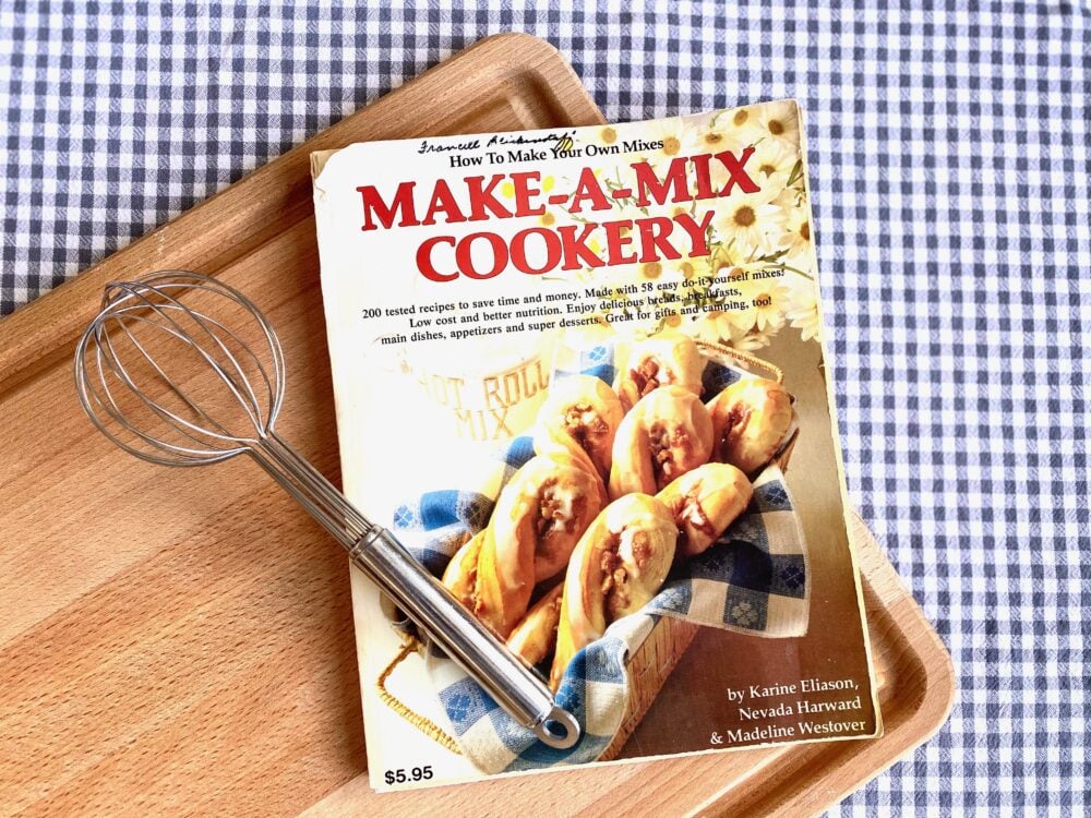 A cookbook called Make A Mix Cookery on a cutting board.