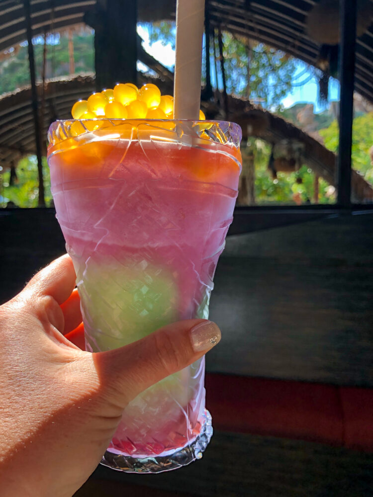 Pongu Pongu smoothie with green and purple in a tall glass. 