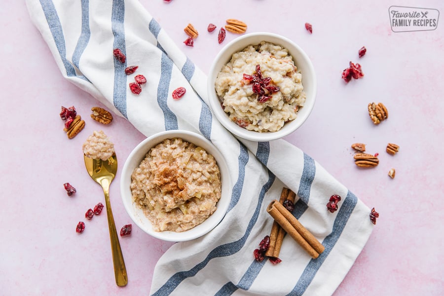 Two bowls of oatmeal on a striped tea towel.