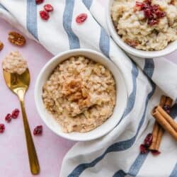 Two bowls of oatmeal on a striped tea towel.