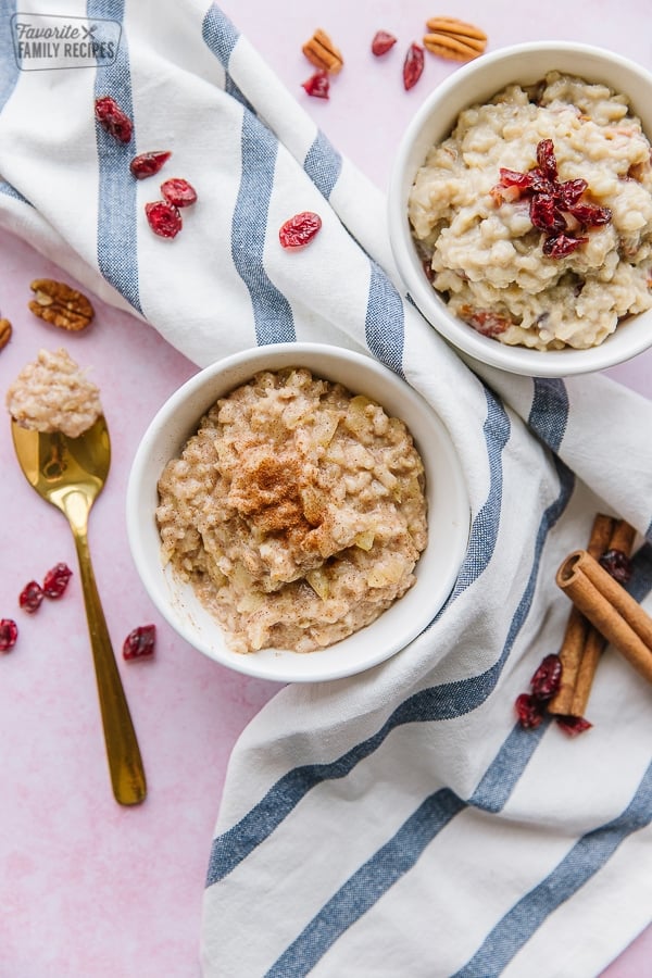 Two bowls of oatmeal on a striped tea towel.