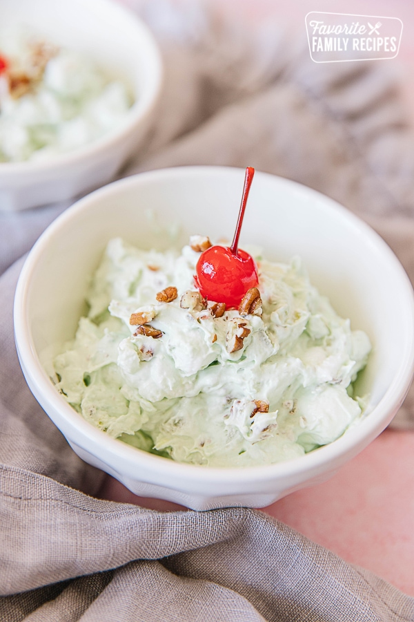 Watergate Salad in a white bowl with a cherry on top
