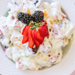Close up view of blackberry fruit salad with fresh strawberries and blackberries on top