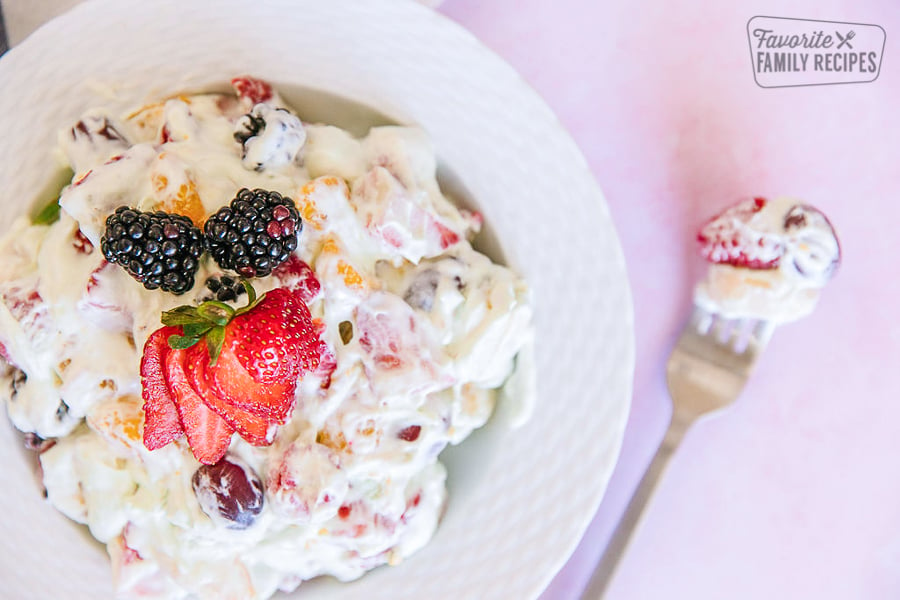 Blackberry Fruit Salad in a white bowl with a fork on the side.