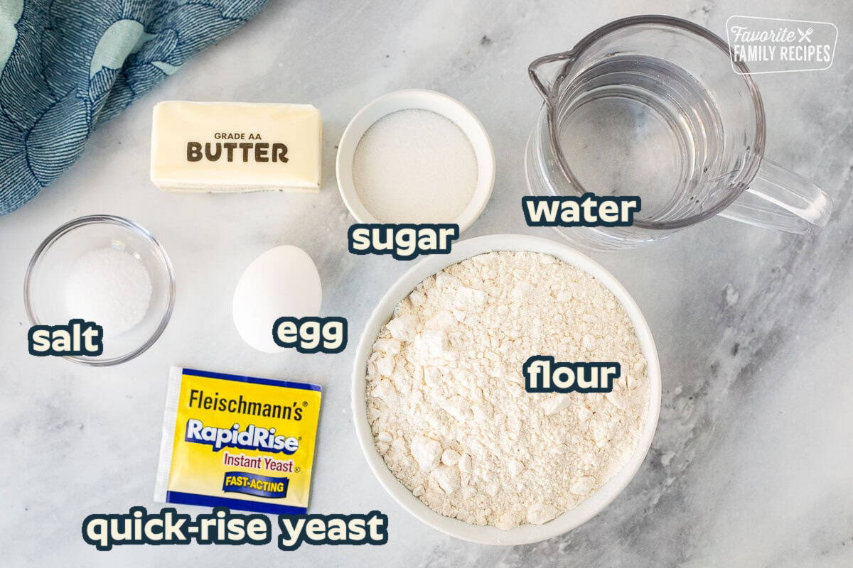 Ingredients to make bread machine bread, including flour, water, sugar, salt, egg butter, and yeast.