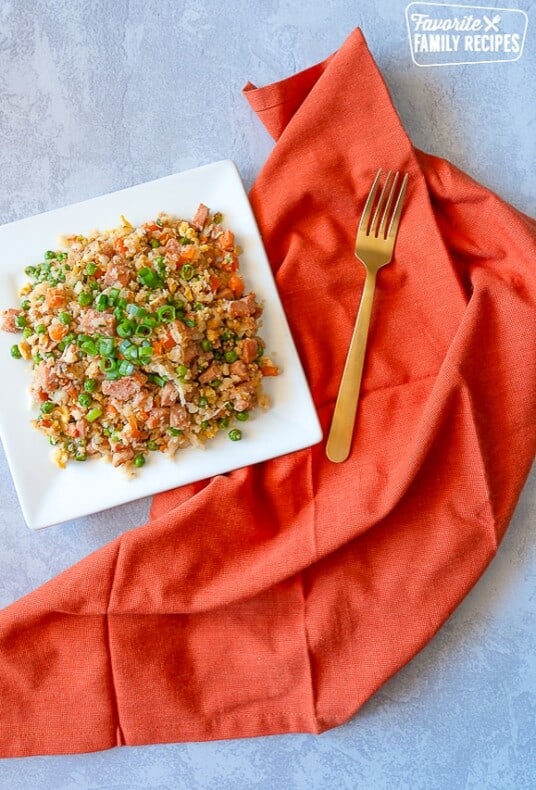 Cauliflower fried rice on a squared white plate.