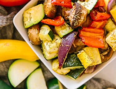 A close up view of oven roasted vegetables in a white bowl