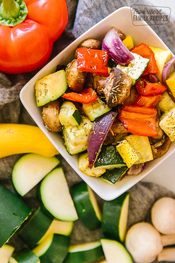 A close up view of oven roasted vegetables in a white bowl