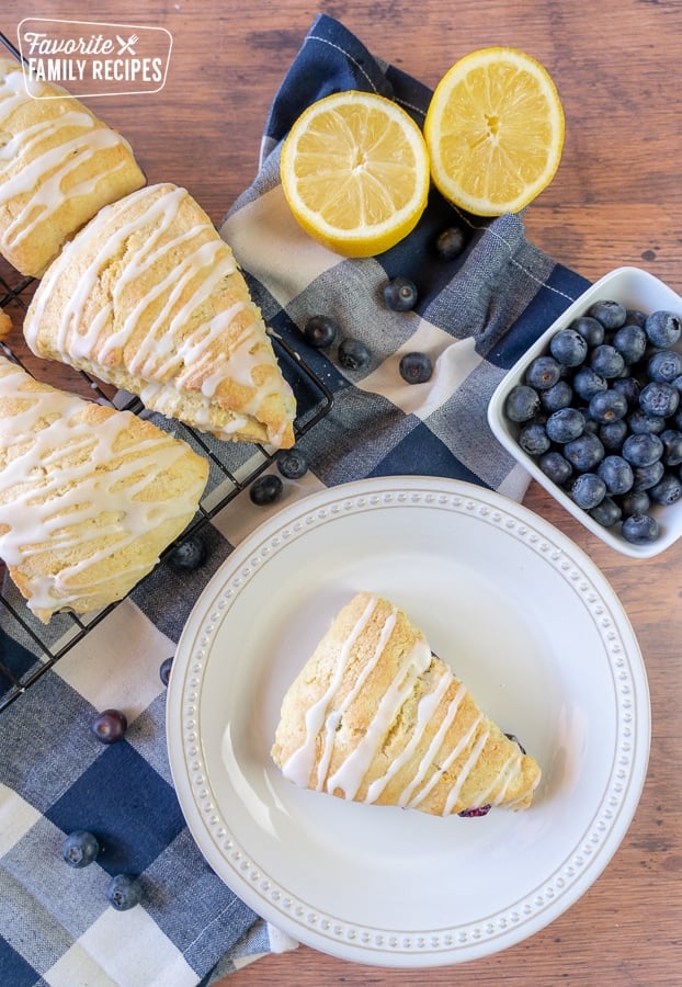 Lemon Blueberry Scones make the perfect addition to any breakfast or brunch. They are soft and fluffy and topped with a sweet and tangy lemon glaze. A lemon blueberry scone on a plate.
