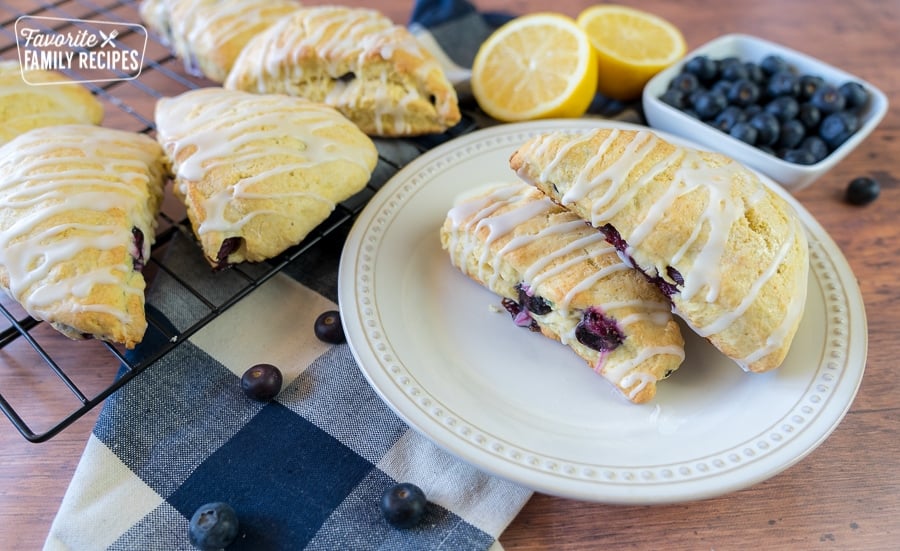 Lemon Blueberry Scones make the perfect addition to any breakfast or brunch. They are soft and fluffy and topped with a sweet and tangy lemon glaze. Lemon Blueberry Scones on a plate with a blue and white checkered napkin.