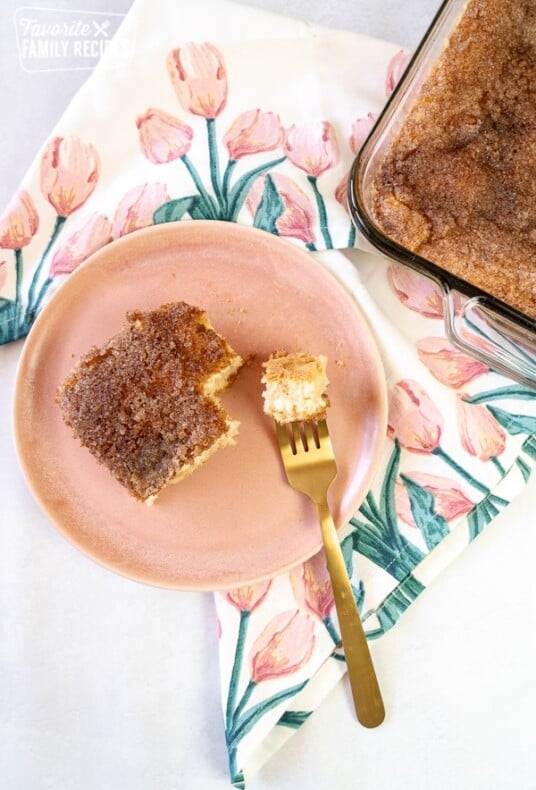 An overview photo of sopaipilla cheesecake with a pink plate.