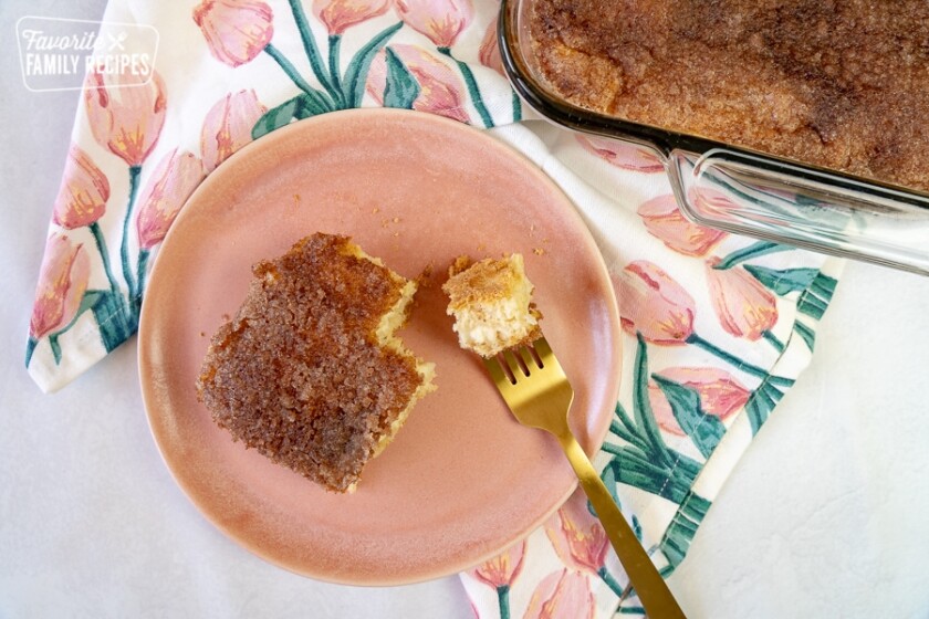 Sopapilla Cheesecake Bars on a pink plate with a bite out of it.
