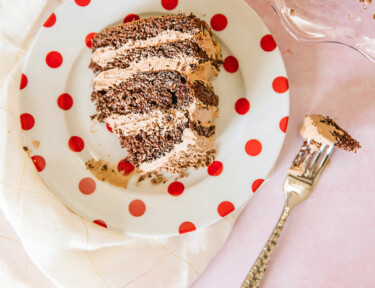 A slice of twice chocolate torte with the full cake to the side