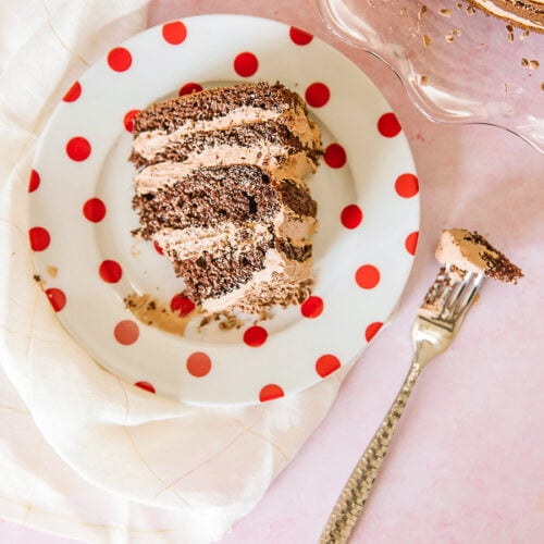 A slice of twice chocolate torte with the full cake to the side