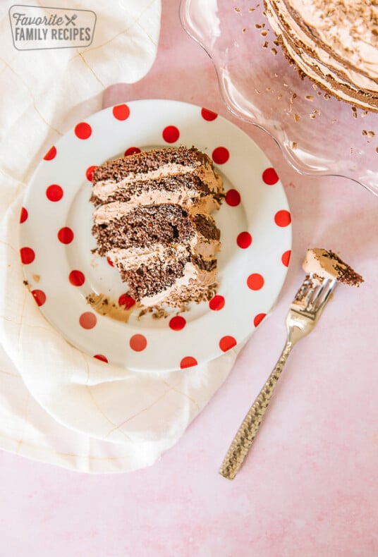 A slice of twice chocolate torte with the full cake to the side