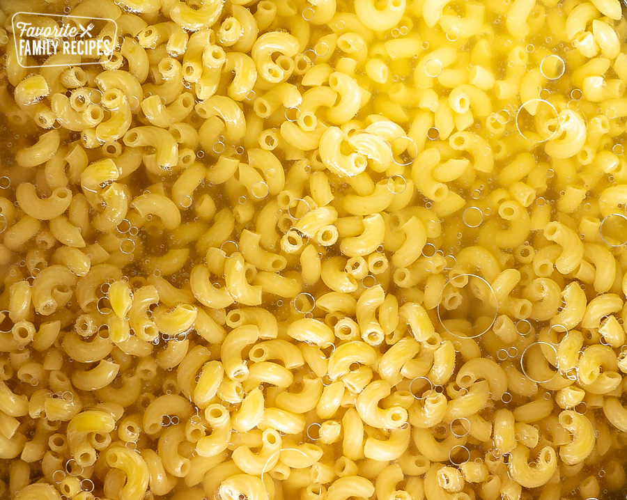 Elbow pasta in water in a pot.