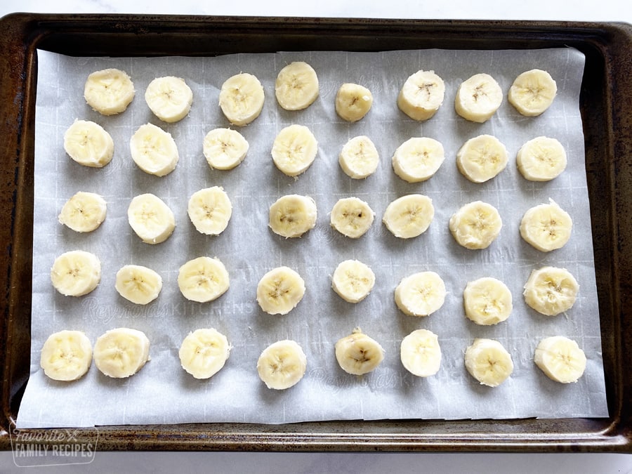 Slices of banana on a baking sheet to freeze.