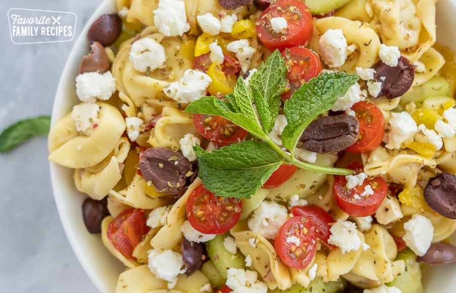 Greek tortellini salad topped with a mint leaf.