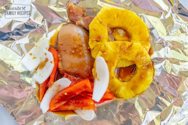 Hawaiian chicken in a foil packet with pineapple, peppers, and onions