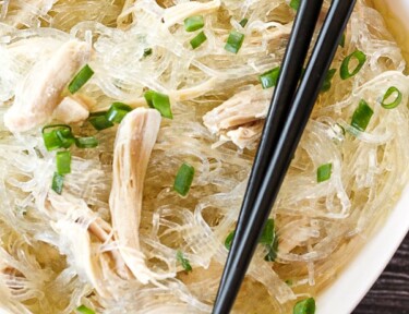 Glass noodles in a bowl with shredded chicken and green onions