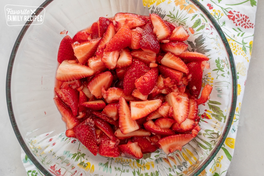 Sliced strawberries in a glass bowl
