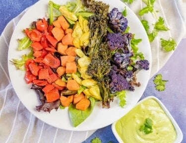 Rainbow Buddha bowl with red, orange, yellow, green, and purple vegetables.