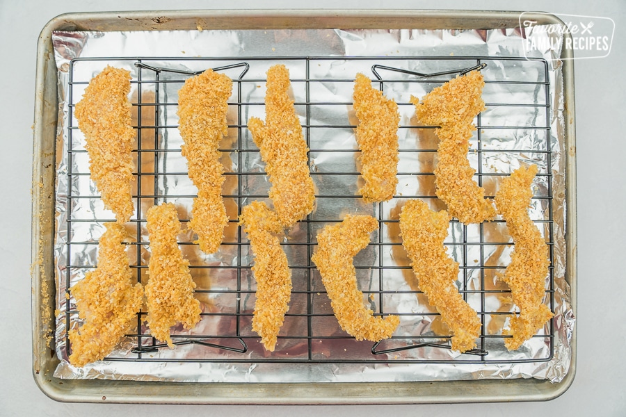 Chicken tenders on a wire rack before they are baked.