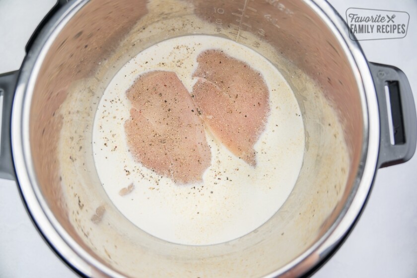 Raw chicken breasts in Alfredo sauce in the Instant Pot