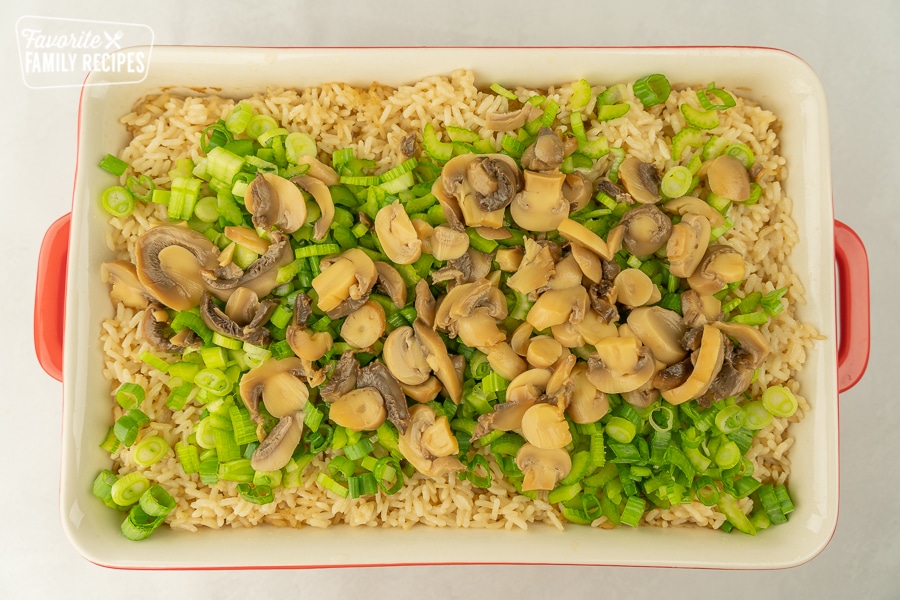 Rice with celery, green onions, mushrooms, and almonds in a large casserole dish.