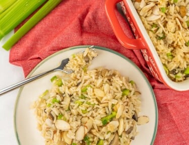 Madres mushroom rice on a white plate with a fork on the side.