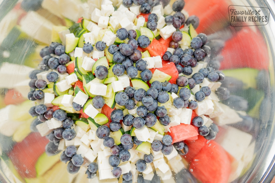 Watermelon, feta, blueberries, and cucumbers in a bowl