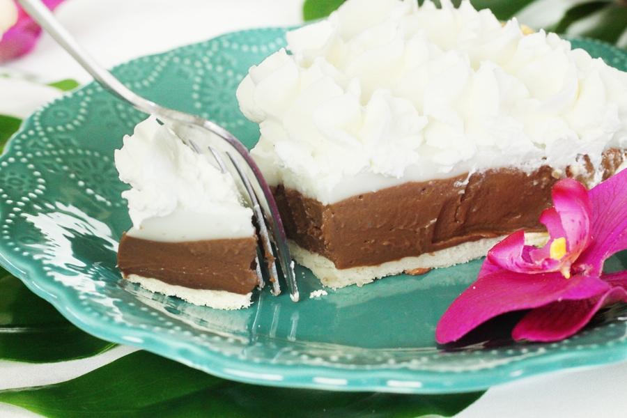 Slice of haupia pie being cut with a fork.