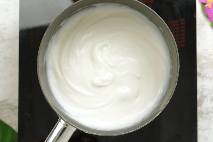 Cornstarch mixture combined and whisked with coconut milk mixture for Coconut milk and sugar in a pot for Authentic Hawaiian Haupia (Coconut Pudding)