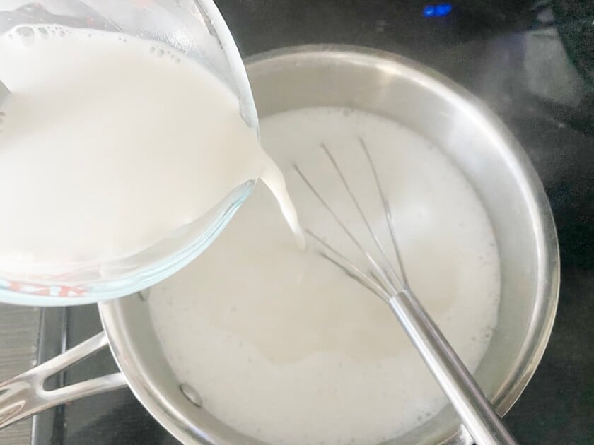 cornstarch mixture being poured into coconut mixture to make haupia