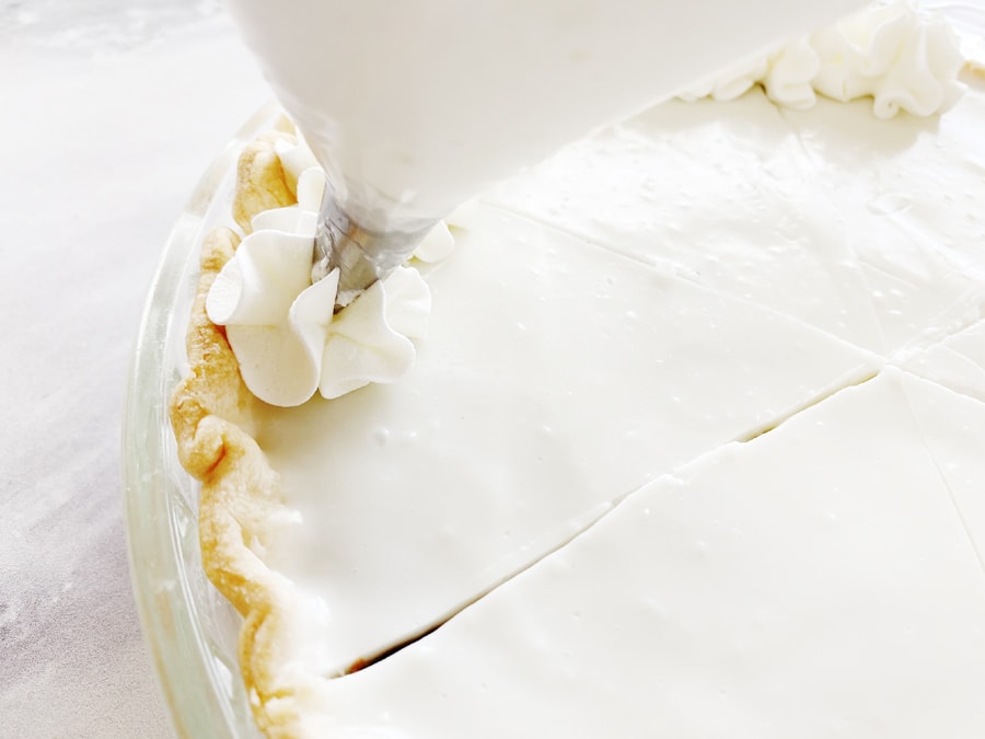 Piping whipped cream onto haupia pie
