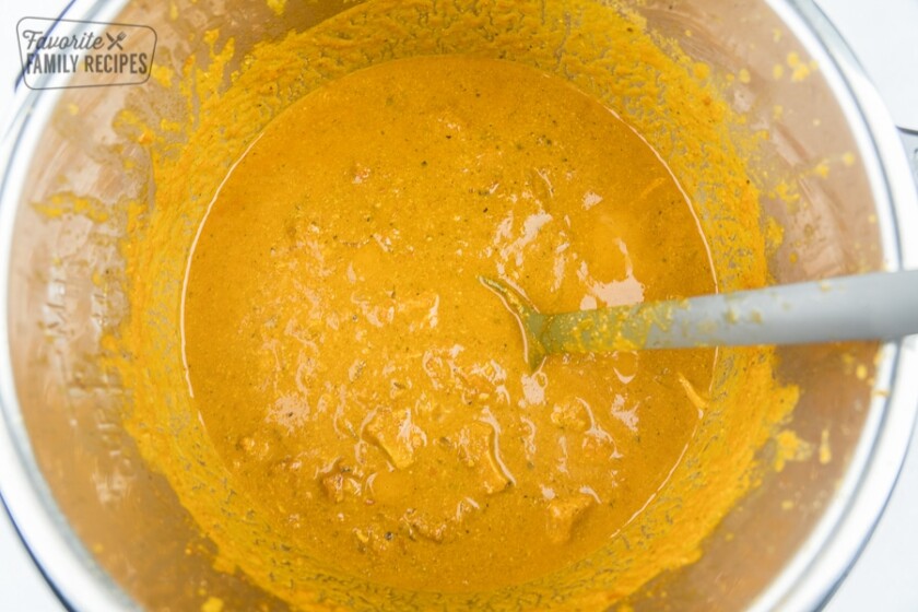 Tikka masala sauce in a mixing bowl with a spoon.