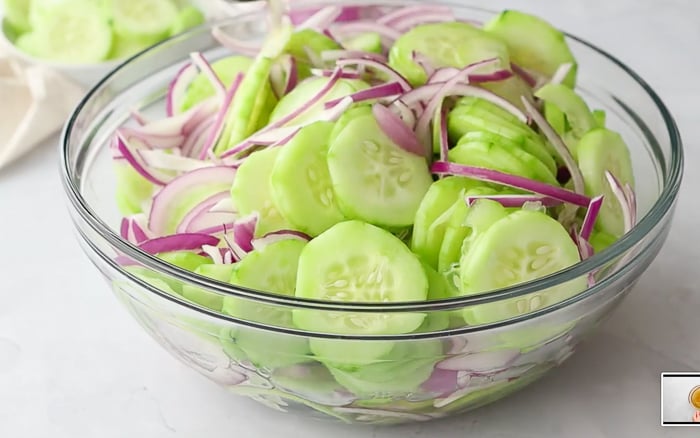 Pouring marinade over cucumbers