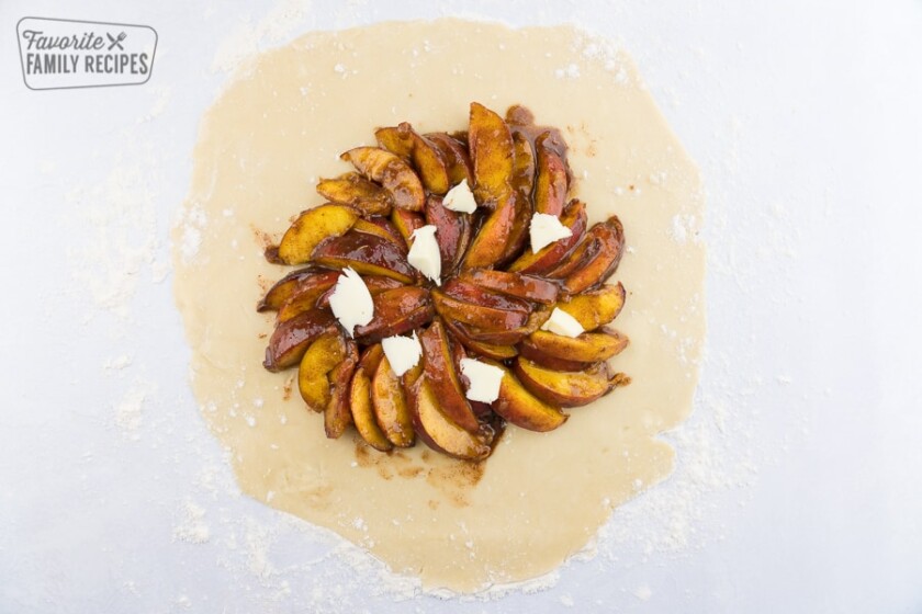 Spiced peaches on a pie crust, topped with chunks of butter.
