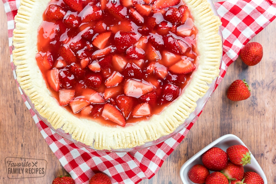 fresh strawberry pie with a bowl of strawberries on the side.