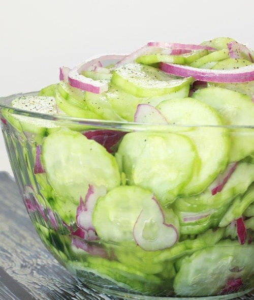 Sliced cucumbers and red onion in cucumber salad