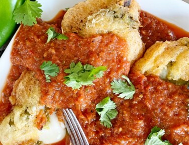 Vertical image of chiles rellenos on a plate with sauce