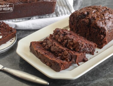 Chocolate zucchini bread sliced on a white platter.