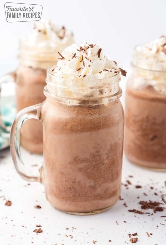 A mug of frozen hot chocolate topped with whipped cream and chocolate shavings