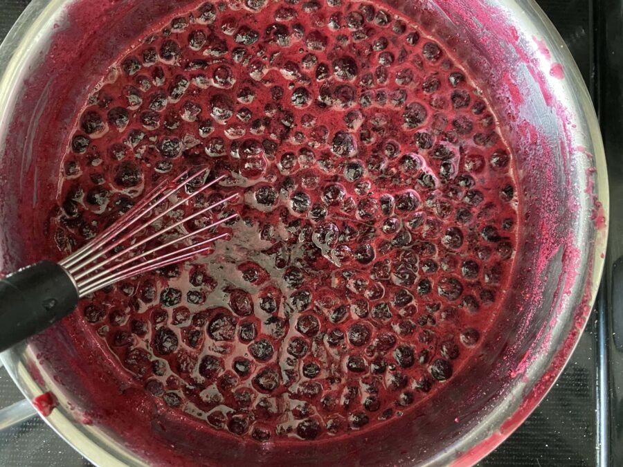 Huckleberry jam in a sauce pan.