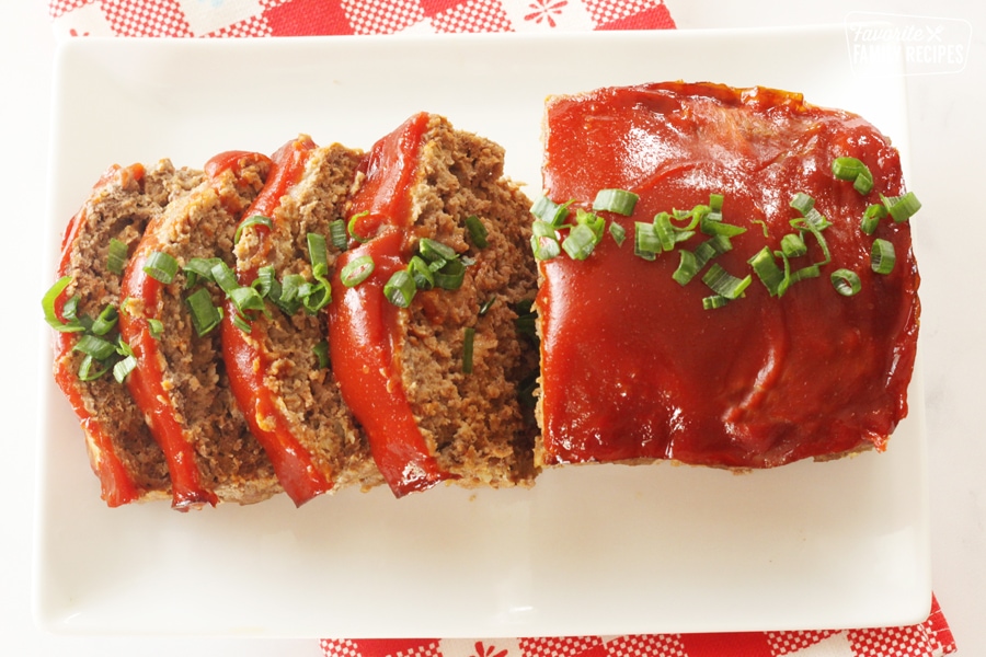 Sliced meatloaf on a platter with glaze.